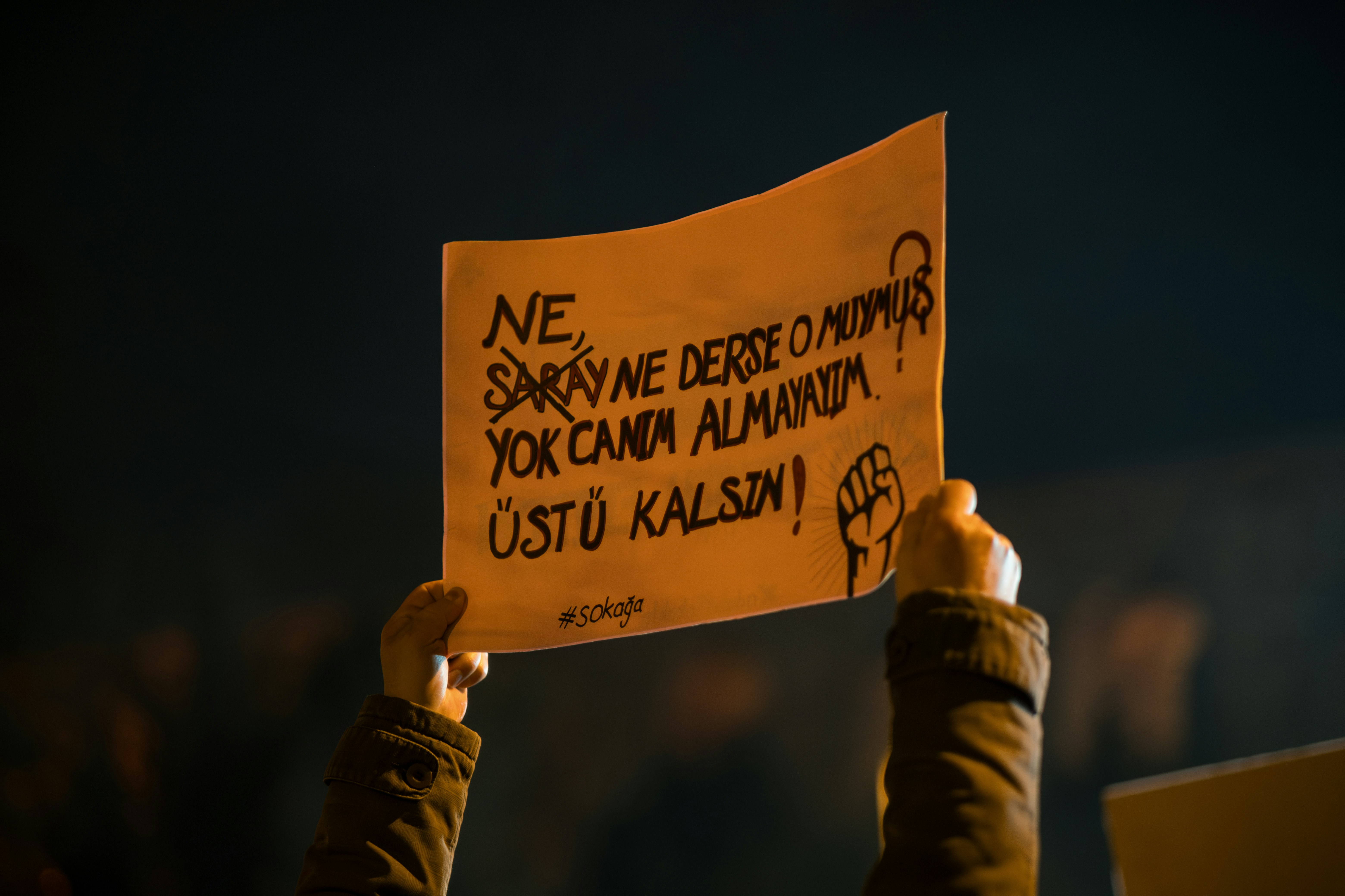 Protester holds sign with turkish text.